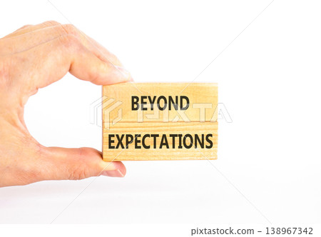 Beyond expectations words symbol. Concept words Beyond expectations on beautiful wooden blocks. Beautiful white background. Businessman hand. Business Beyond expectations words concept. Copy space. 138967342