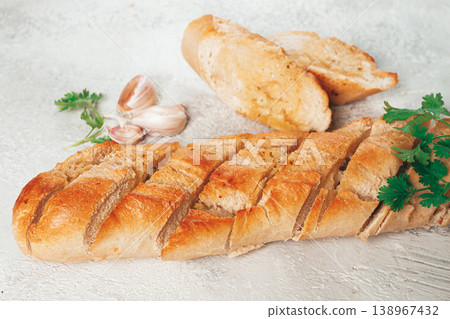 garlic bread,baguette with garlic butter and herbs, on a light table, top view, garlic bread,baguette with garlic butter and herbs, on a light table, top view, 138967432