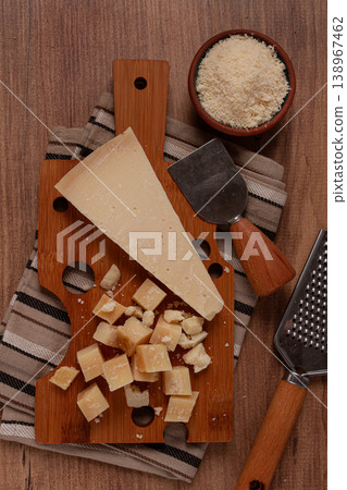 Freshly sliced and grated cheese, parmesan cheese, on a wooden chopping board, rustic style, no people 138967462