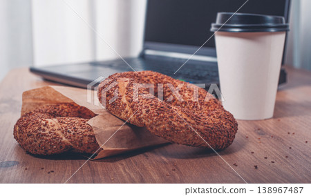 simits with coffee on a wooden table, with a laptop, in a cozy working environment, snack, breakfast, no people, 138967487