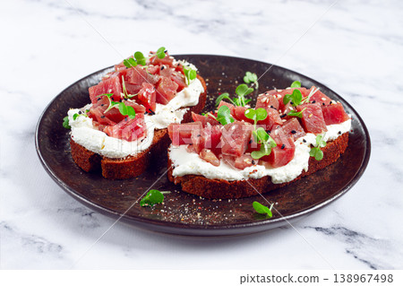 sandwiches, rye bread with cream cheese, sliced tuna fillet with herbs, breakfast on a black plate, homemade, sandwiches, rye bread with cream cheese, sliced tuna fillet with herbs, breakfast on a black plate, homemade, 138967498