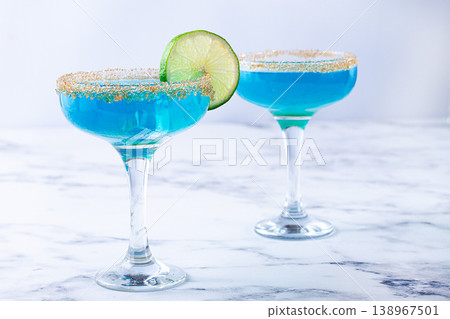 Colorful blue cocktails in elegant glasses with lime garnish on a marble table 138967501