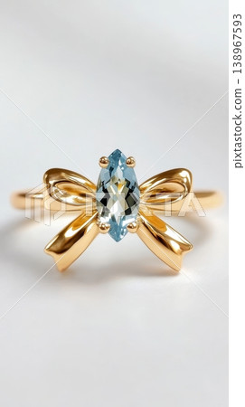 Gold bow ring with blue gemstone on white background 138967593