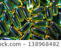 Omega 3 fish oil capsules close up on green background, glossy softgel supplements, healthcare and wellness concept 138968482