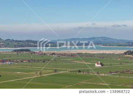 Countryside fields and lake with small church in Bavaria Germany under soft haze Countryside fields and lake with small church in Bavaria Germany under soft haze 138968722