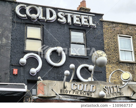 London UK 05.07.2025 Cold Steel body piercing shop facade with large industrial ring sculptures on building exterior in Camden showcasing bold design and alternative urban culture atmosphere 138968737
