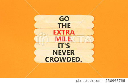 Go the extra mile symbol. Concept words Go the extra mile. It's never crowded on beautiful wooden sticks. Beautiful orange paper background. Business go the extra mile concept. Copy space. Go the extra mile symbol. Concept words Go the extra mile. It's never crowded on beautiful wooden sticks. Beautiful orange paper background. Business go the extra mile concept. Copy space. 138968766