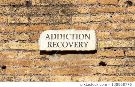 Addiction recovery symbol. Concept words Addiction recovery on beautiful big white sign plate. Beautiful old brown brick wall background. Psychology addiction recovery concept. Copy space. 138968776