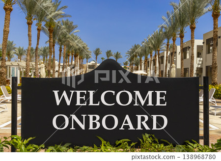 Welcome onboard symbol. Concept words Welcome onboard on beautiful big black road sign. Beautiful blue sky palm trees background. Business, motivational welcome onboard concept. Copy space. Welcome onboard symbol. Concept words Welcome onboard on beautiful big black road sign. Beautiful blue sky palm trees background. Business, motivational welcome onboard concept. Copy space. 138968780
