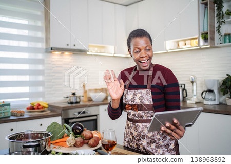 Woman cooking and having a video call on digital tablet 138968892
