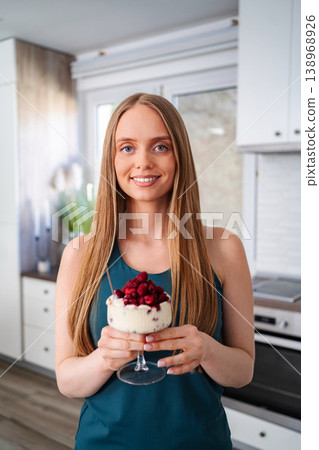 Young adult woman holding healthy raspberry yogurt dessert Young adult woman holding healthy raspberry yogurt dessert 138968926