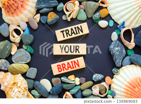 Train your brain words symbol. Concept words Train your brain on beautiful wooden blocks. Beautiful black background. Sea stones and shells. Business motivational train your brain concept. Copy space 138969083