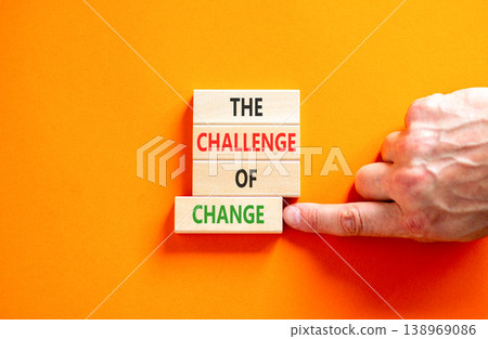 The challenge of change symbol. Concept words The challenge of change on beautiful wooden blocks. Beautiful orange background. Businessman hand. Business the challenge of change concept. Copy space. The challenge of change symbol. Concept words The challenge of change on beautiful wooden blocks. Beautiful orange background. Businessman hand. Business the challenge of change concept. Copy space. 138969086