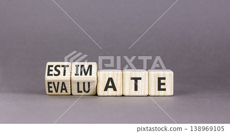 Estimate or evaluate symbol. Concept words Evaluate to Estimate on beautiful wooden cubes. Beautiful grey table grey background. Business, estimate or evaluate concept. Copy space. 138969105