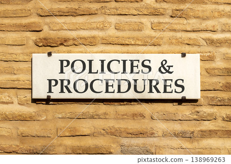 Policies and procedures symbol. Concept words Policies and procedures on beautiful big white sign plate. Beautiful old brown brick wall background. Business policies procedures concept. Copy space 138969263