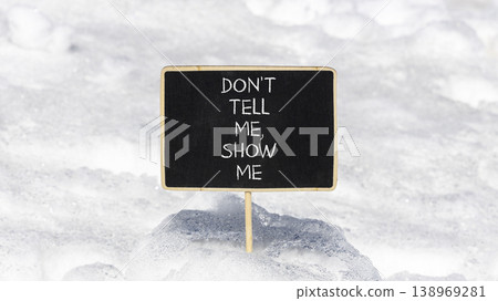 Tell or show symbol. Concept words Do not tell me, show me on beautiful black blackboard. Beautiful white snow background. Business tell or show concept. Copy space. Tell or show symbol. Concept words Do not tell me, show me on beautiful black blackboard. Beautiful white snow background. Business tell or show concept. Copy space. 138969281