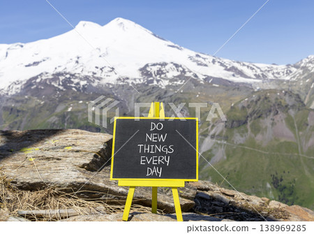 Do new things every day words symbol. Concept words Do new things every day on beautiful black blackboard. Beautiful mountain Elbrus background. Business do new things every day concept. Copy space. 138969285