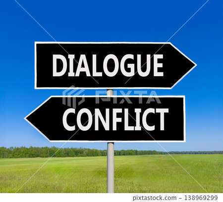 Dialogue instead conflict symbol. Concept words Dialogue and Conflict on beautiful black road sign. Beautiful blue sky green grass background. Social and dialogue instead conflict concept. Copy space. 138969299