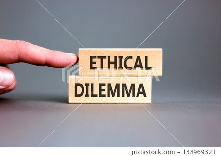 Ethical dilemma words symbol. Concept words Ethical dilemma on beautiful wooden blocks. Beautiful grey background. Businessman hand. Business and Ethical dilemma words concept. Copy space. 138969321