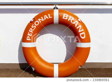 Personal brand symbol. Concept words Personal brand on beautiful orange lifebuoy. Beautiful white ship's board background. Business personal brand concept. Copy space. Personal brand symbol. Concept words Personal brand on beautiful orange lifebuoy. Beautiful white ship's board background. Business personal brand concept. Copy space. 138969361