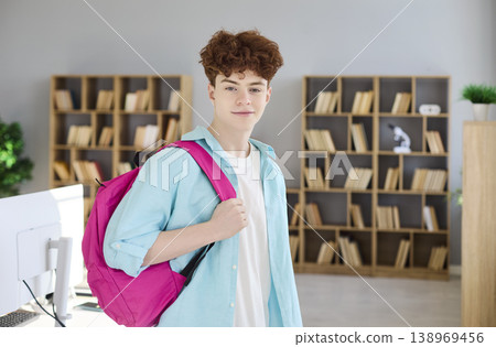 Confident teen student with backpack in bright library, ready for study and school 138969456