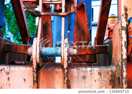 Close up of rusty crane machinery showing metal joints, cables, and hydraulic components in an industrial construction setting. Close up of rusty crane machinery showing metal joints, cables, and hydraulic components in an industrial construction setting. 138969710