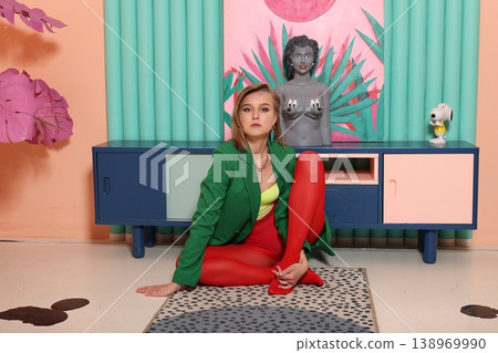 Casually seated young lady with expressive face and bright artistic decor Casually seated young lady with expressive face and bright artistic decor 138969990