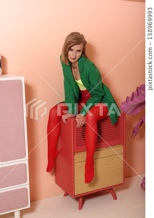 Casual female seated with vibrant clothing and warm setting background 138969993