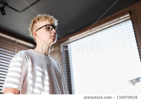 Caucasian entrepreneur observes through blinds with determination 138970026