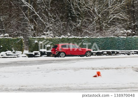 Hatchback expertly passing cones during winter handling practice 138970048
