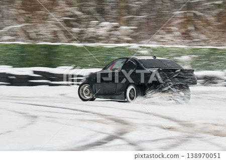 Automobile in black creates dynamic snow spray display with arc Automobile in black creates dynamic snow spray display with arc 138970051
