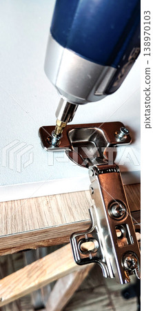 Cordless screwdriver for attaching a hinge to a furniture panel 138970103