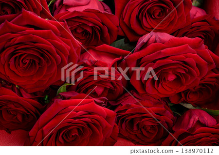 A luxurious bouquet of dark red roses close-up with a velvety texture. A luxurious bouquet of dark red roses close-up with a velvety texture. 138970112