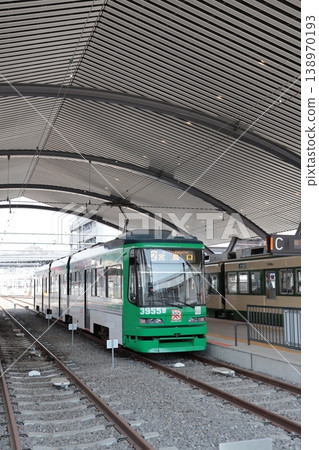 A streetcar stopped at the platform of Hiroden Miyajimaguchi Station on the Hiroshima Electric Railway Miyajima Line. 138970193