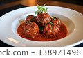Italian meatballs simmering in rich tomato sauce with fresh herbs 138971496