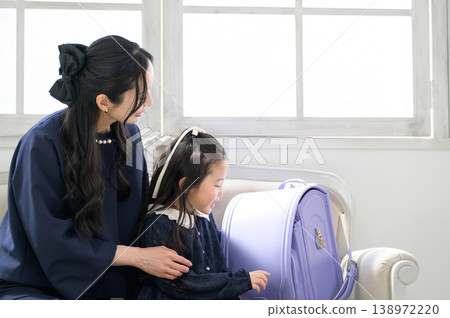 A Japanese parent and child talking with school bags beside them. A Japanese parent and child talking with school bags beside them. 138972220