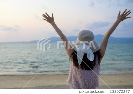 The back view of a Japanese woman who is happy watching the sunset over the sea. The back view of a Japanese woman who is happy watching the sunset over the sea. 138972277