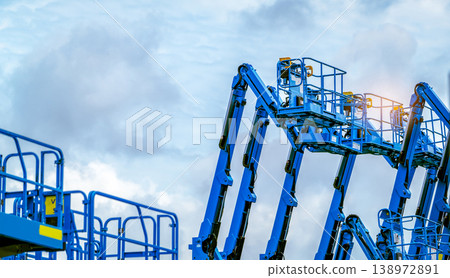 Articulated boom lift. Aerial platform lift. Telescopic boom lift against blue sky. Mobile construction crane for rent and sale. Maintenance and repair hydraulic boom lift service. Crane dealership. Articulated boom lift. Aerial platform lift. Telescopic boom lift against blue sky. Mobile construction crane for rent and sale. Maintenance and repair hydraulic boom lift service. Crane dealership. 138972891
