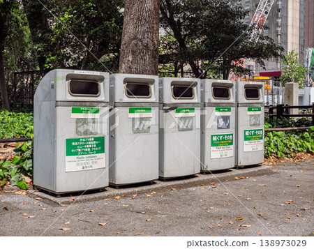 Rows of sorting trash cans installed in a park: visual guidance and multilingual information. Rows of sorting trash cans installed in a park: visual guidance and multilingual information. 138973029