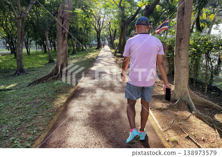 Rear of fit old man walk exercise in greenery park at sunrise, Nonthaburi Rear of fit old man walk exercise in greenery park at sunrise, Nonthaburi 138973579