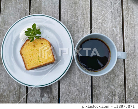 An overhead photograph of coffee and pound cake arranged on a wooden table. An overhead photograph of coffee and pound cake arranged on a wooden table. 138973871