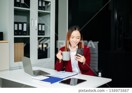 Confident businesswomen working on finance analysis with a tablet and laptop at office desk. Perfect for business, accounting Confident businesswomen working on finance analysis with a tablet and laptop at office desk. Perfect for business, accounting 138973887