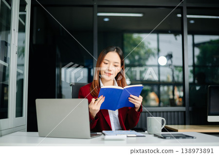 Portrait of a young women sitting at his desk in the office. 138973891