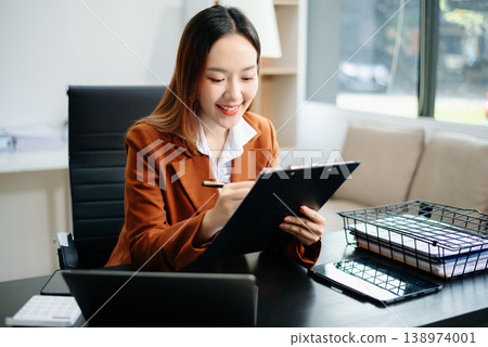Asian working on laptops and tablets in a stylish office. Perfect for creativity, remote work, modern lifestyle, and startup themes. Asian working on laptops and tablets in a stylish office. Perfect for creativity, remote work, modern lifestyle, and startup themes. 138974001
