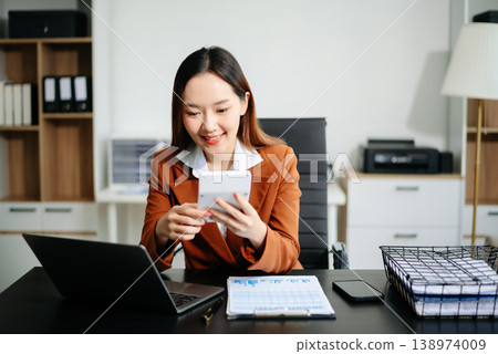 Asian working on laptops and tablets in a stylish office. Perfect for creativity, remote work, modern lifestyle, and startup themes. Asian working on laptops and tablets in a stylish office. Perfect for creativity, remote work, modern lifestyle, and startup themes. 138974009