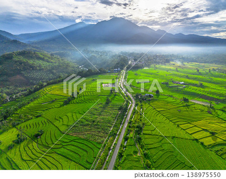 Beautiful morning view in Indonesia, panoramic landscape of rice fields with mountain ranges and clear sky Beautiful morning view in Indonesia, panoramic landscape of rice fields with mountain ranges and clear sky 138975550