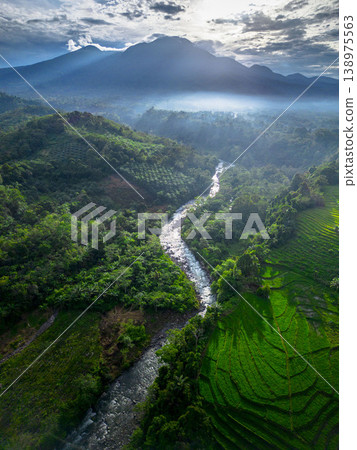 Beautiful morning view in Indonesia, panoramic landscape of rice fields with mountain ranges and clear sky 138975563