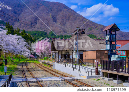 Spring scenery at Yunokami Onsen Station in Fukushima Prefecture: Cherry blossoms in full bloom and a thatched-roof station building. 138975899