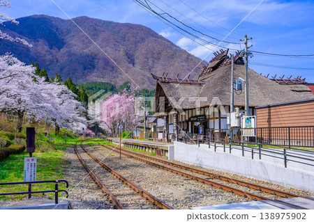 Yunokami Onsen Station, a thatched-roof post station adorned with majestic mountain ranges and cherry blossoms in full bloom. Yunokami Onsen Station, a thatched-roof post station adorned with majestic mountain ranges and cherry blossoms in full bloom. 138975902