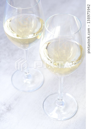 一張吐司的圖片，上面有兩個裝滿白酒的酒杯 138975942